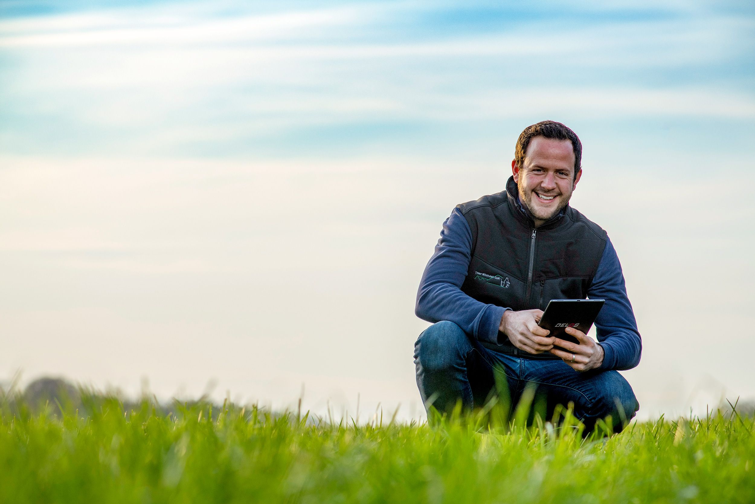 Landwirt mit Tablet auf Ackergras